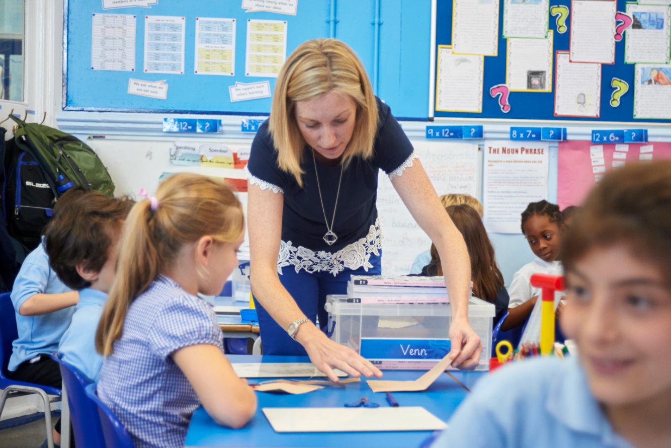 Photo of a maths teacher giving an example of how to use concrete resources to primary students