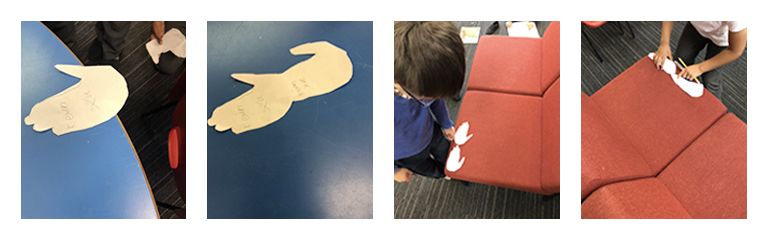 Students using cut outs of hand and feet to measure 