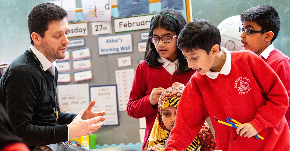 Maths teacher explaining problem to curious pupils.