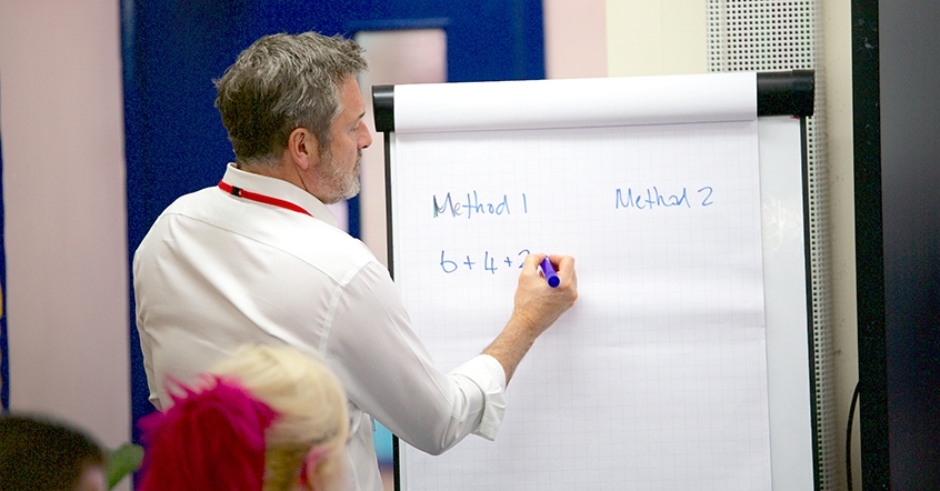 CPD trainer giving lesson to maths teachers.