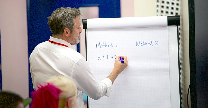 CPD trainer giving lesson to maths teachers.