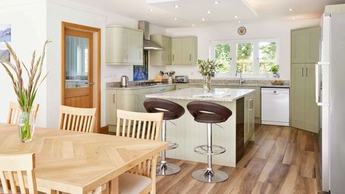 Sage kitchen with island and stools