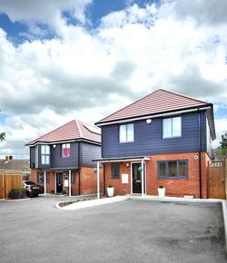 Two detached houses with red bricks and anthracite cladding