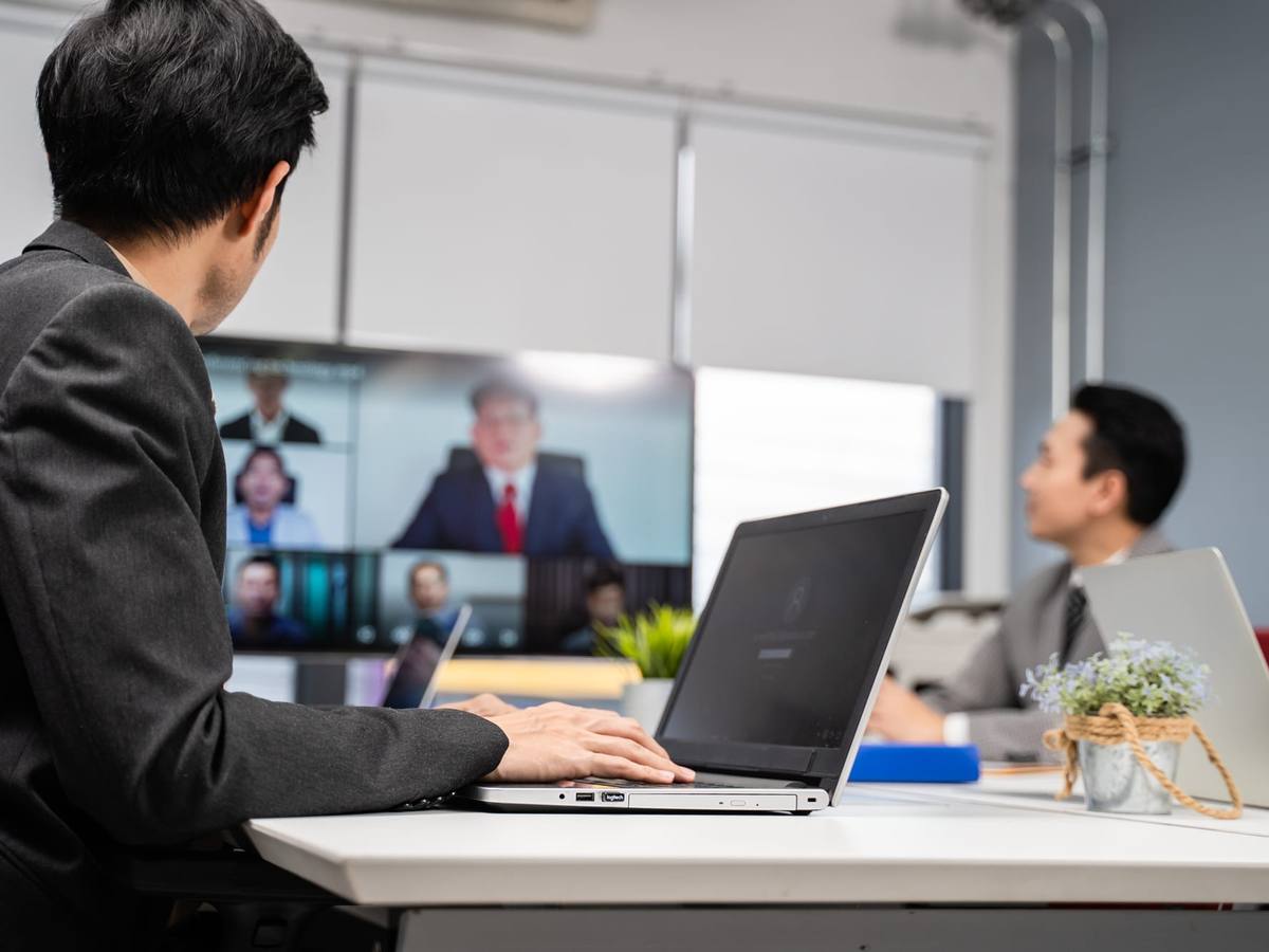 A businessman on a video conference with a client at a meeting table