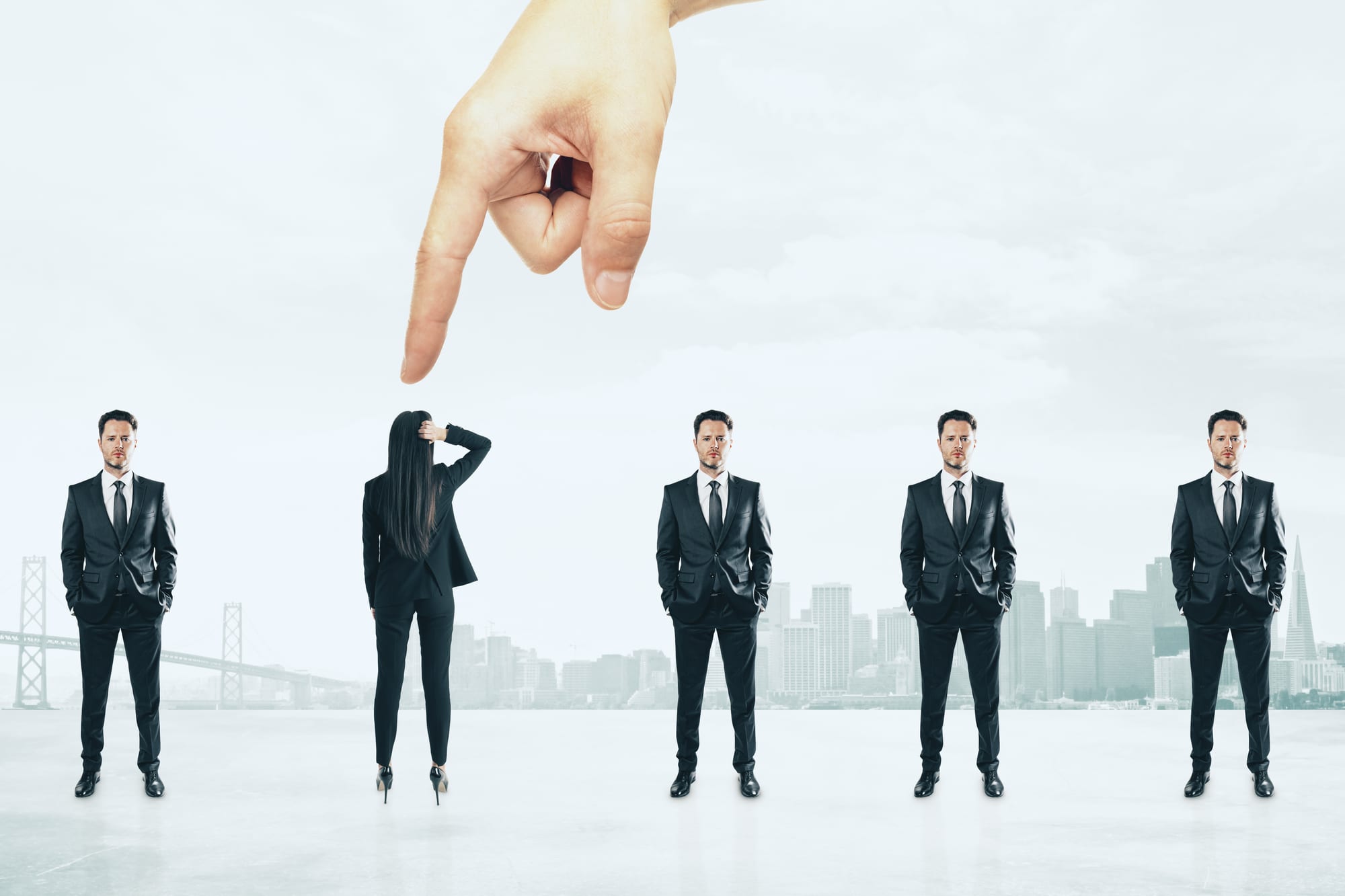 A hand pointing down to pick one person from a line of business people