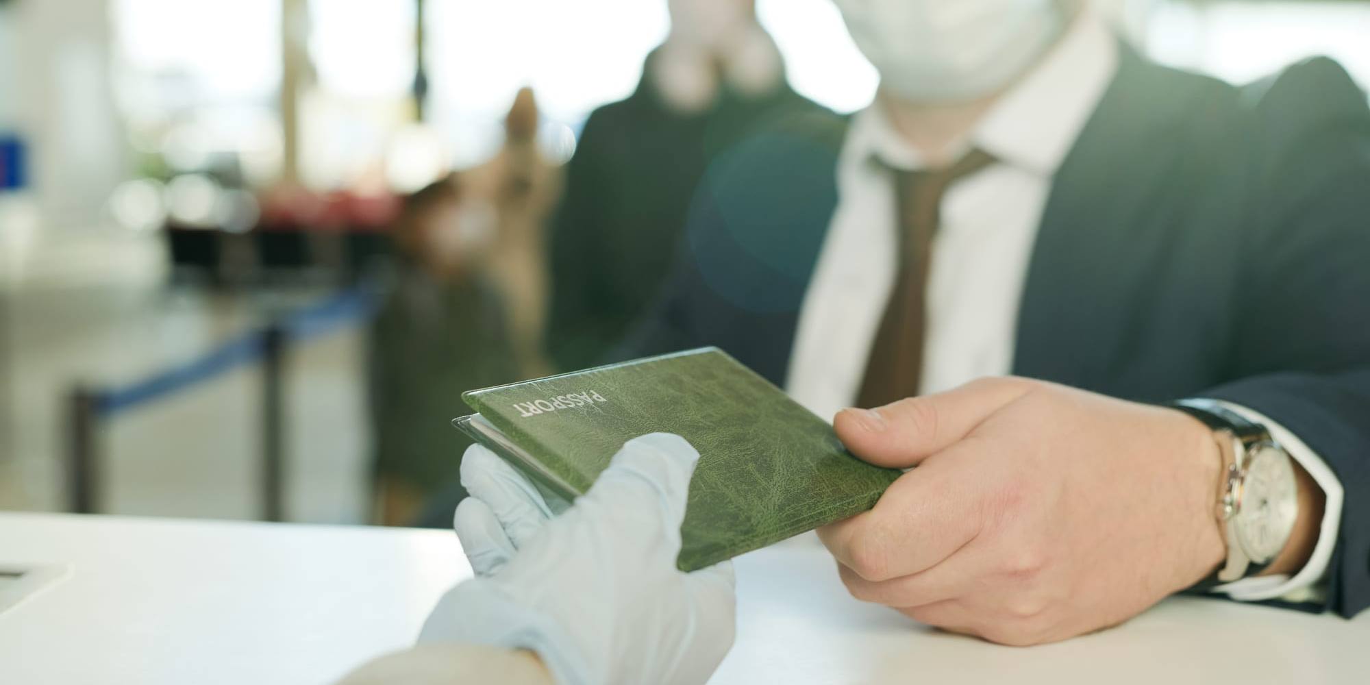 An official checking a passport at a security desk