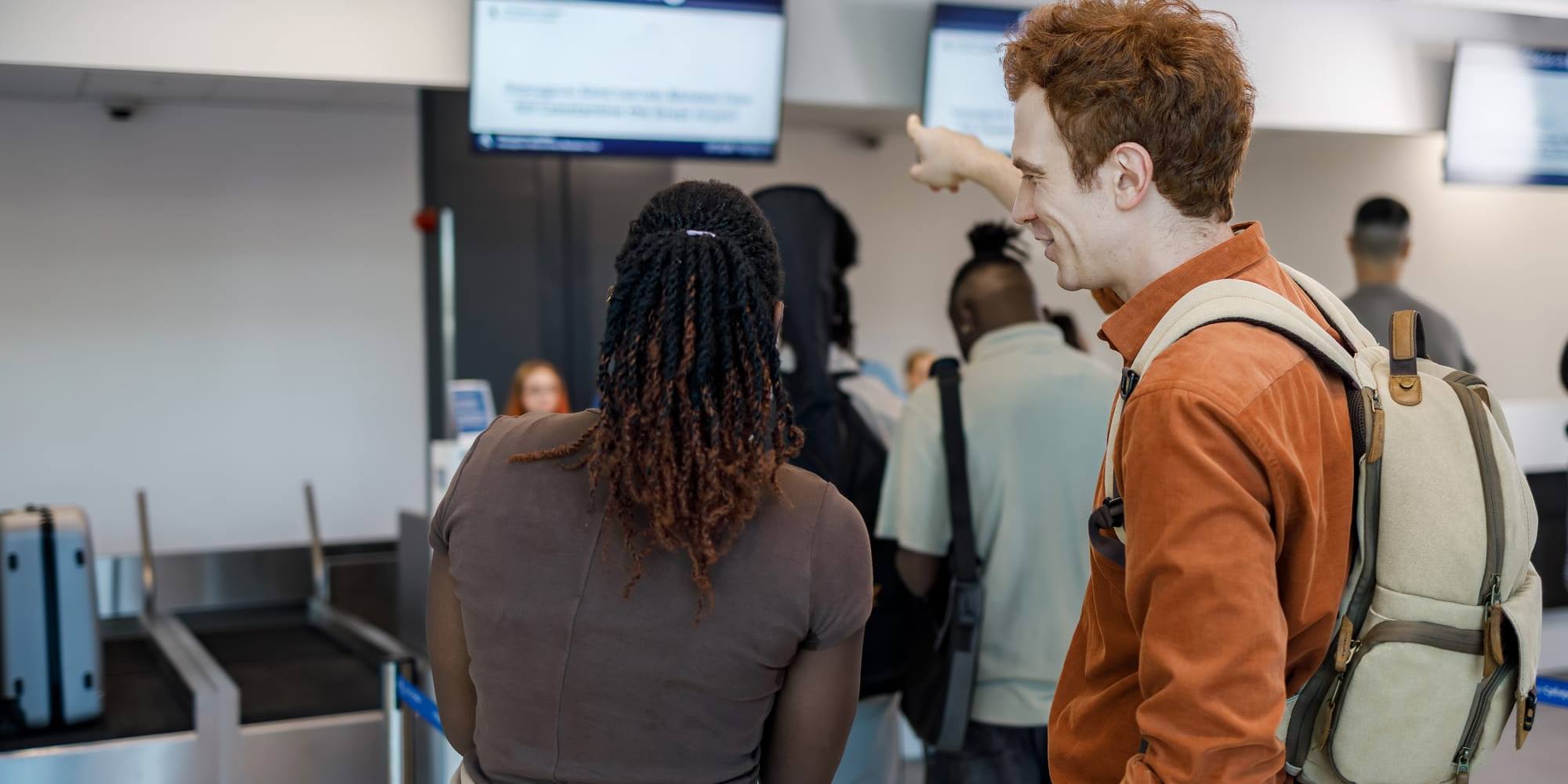 Travellers queuing at an airport check-in counter
