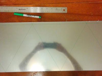 Half-mirrored acrylic sheets with faint green lines tracing the triangles to be cut out