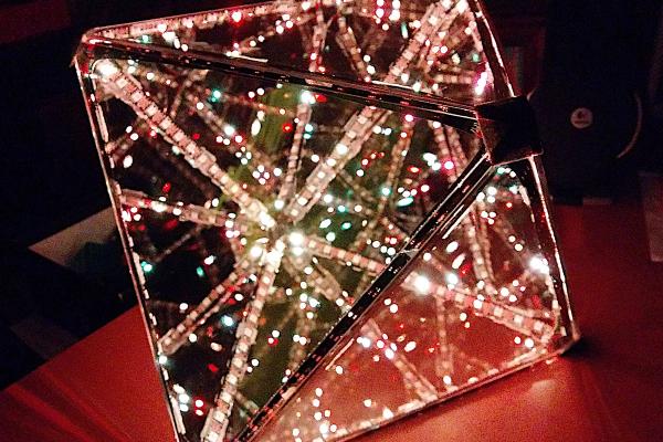 An octahedron with half mirrored faces, reflecting and transmitting the multicolored LEDs installed internally along the edges