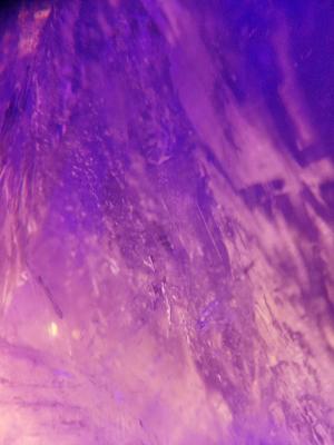 A close-up of the quartz crystal illuminated by LEDs in shades of violet and lilac