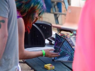 Girl with rainbow-colored hair looking into the octahedral infinity mirror