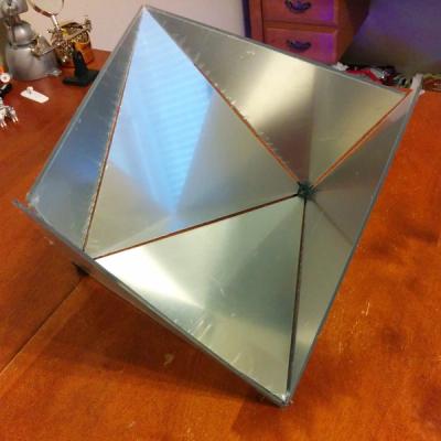 A partially assembled octahedron made with 3D-printed vertex connectors and half-mirrored acrylic faces
