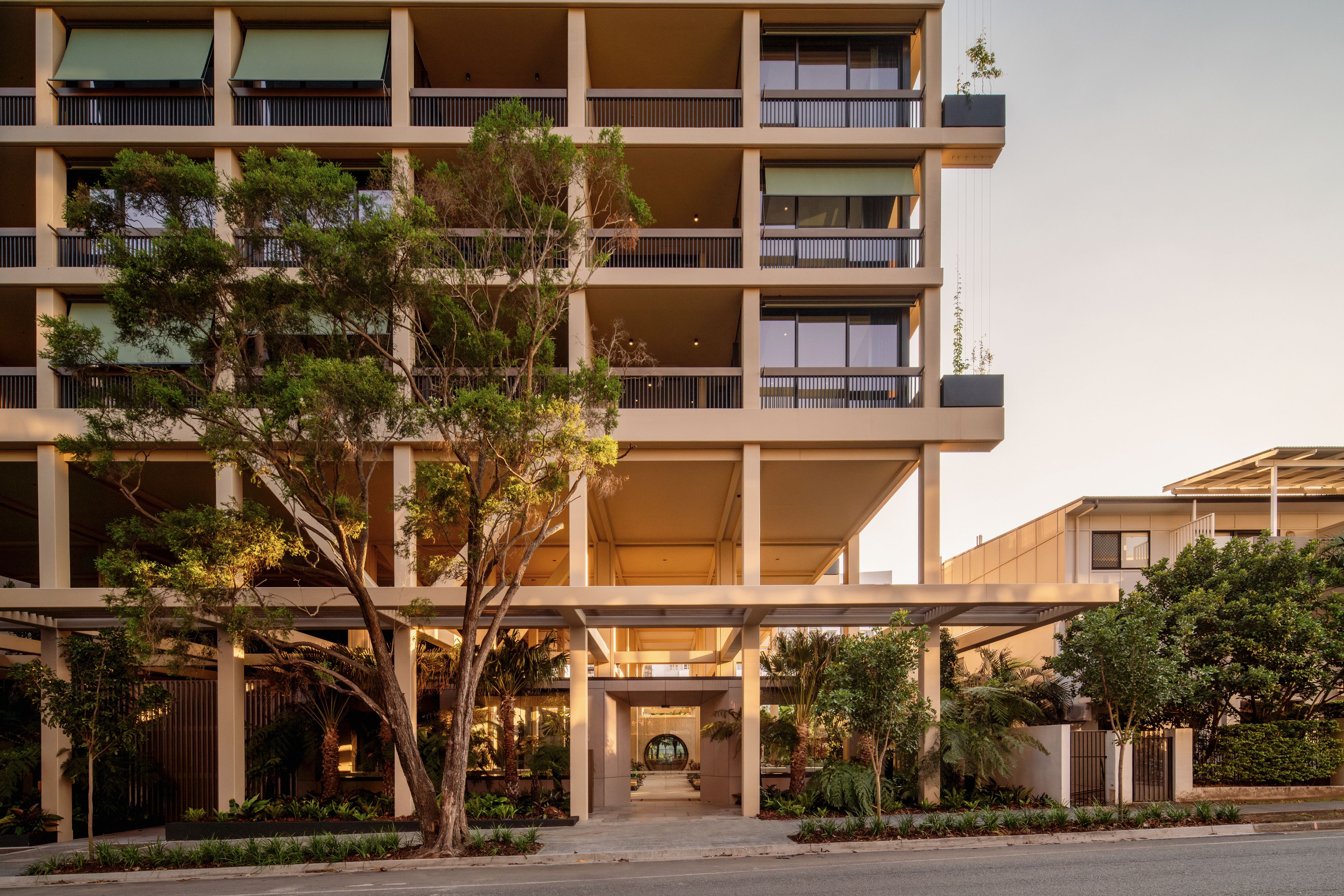 Trellis by Aria in Brisbane, Queenslander inspired façade including lush greenery and sunset skies in Brisbane city.