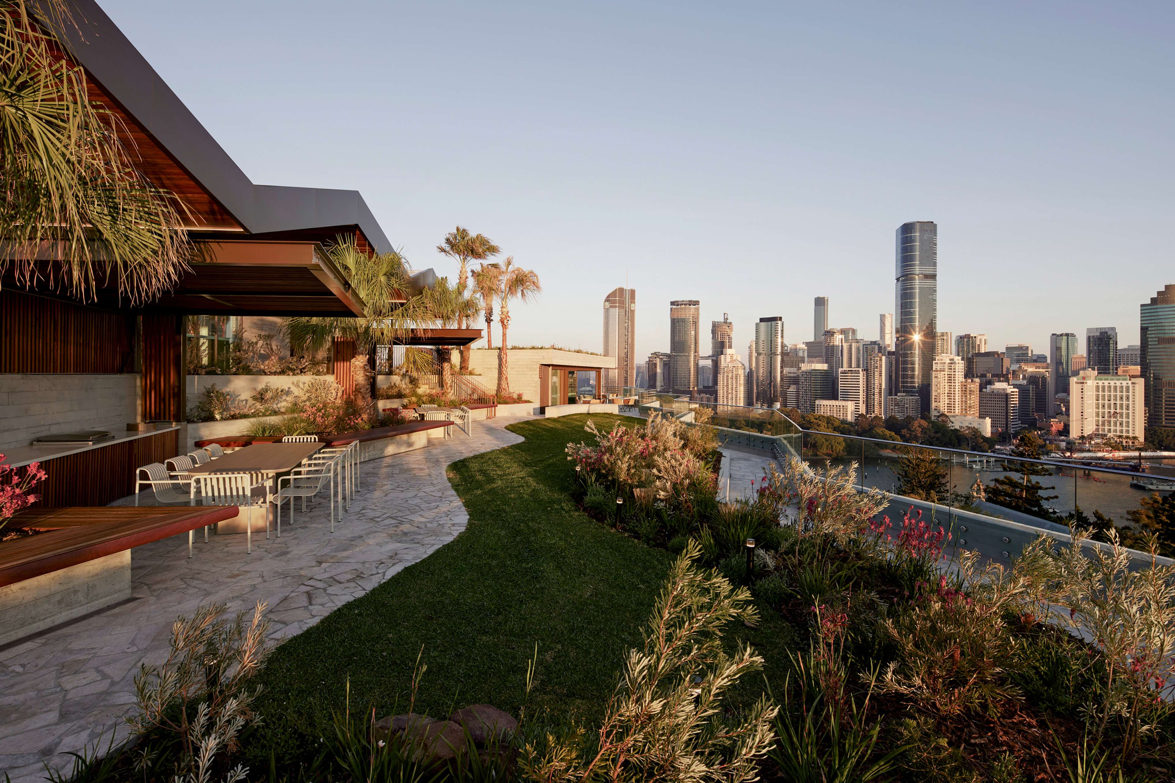 The rooftop meadow and lawn at Rivière by Aria, with views to the Brisbane city skyline