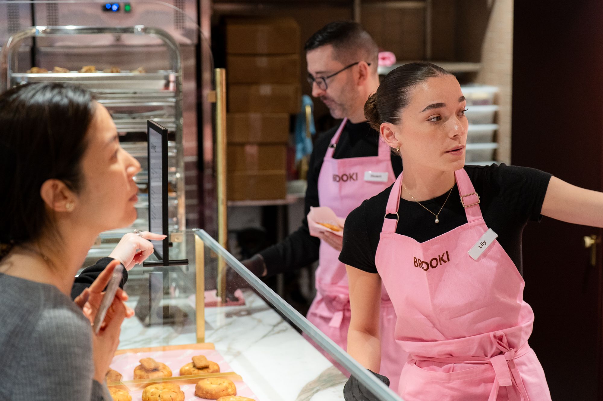 Brooki staff serving customers at the cabinet