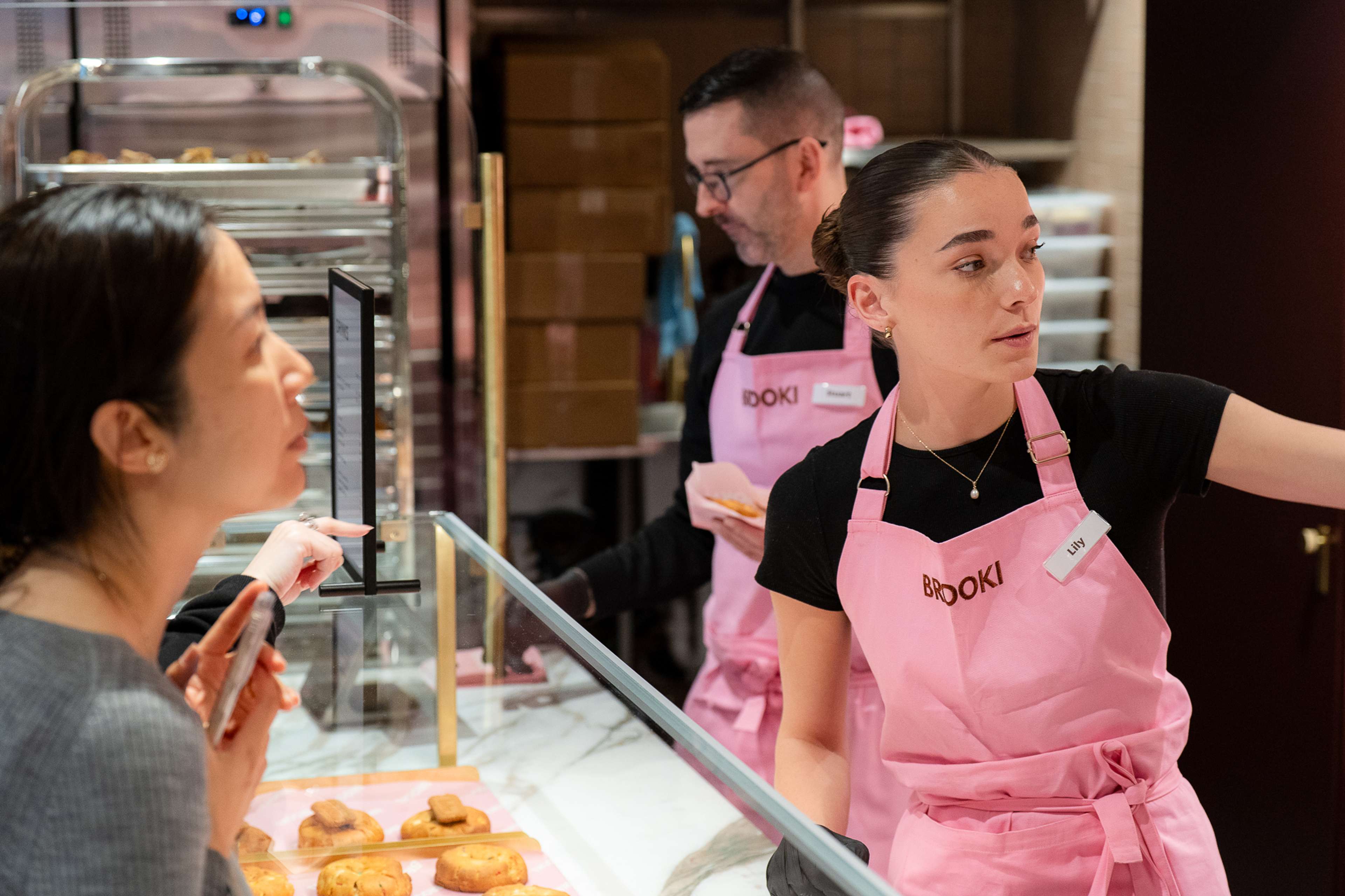 Brooki staff serving customers at the cabinet