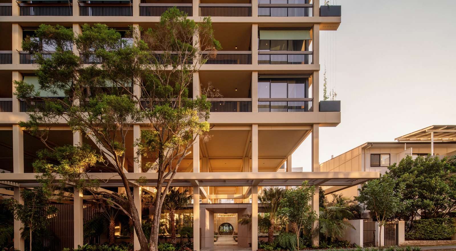 Trellis by Aria in Brisbane, Queenslander inspired façade including lush greenery and sunset skies in Brisbane city.