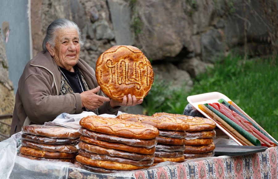 Local woman selling a large, round Armenian pastry called Gata