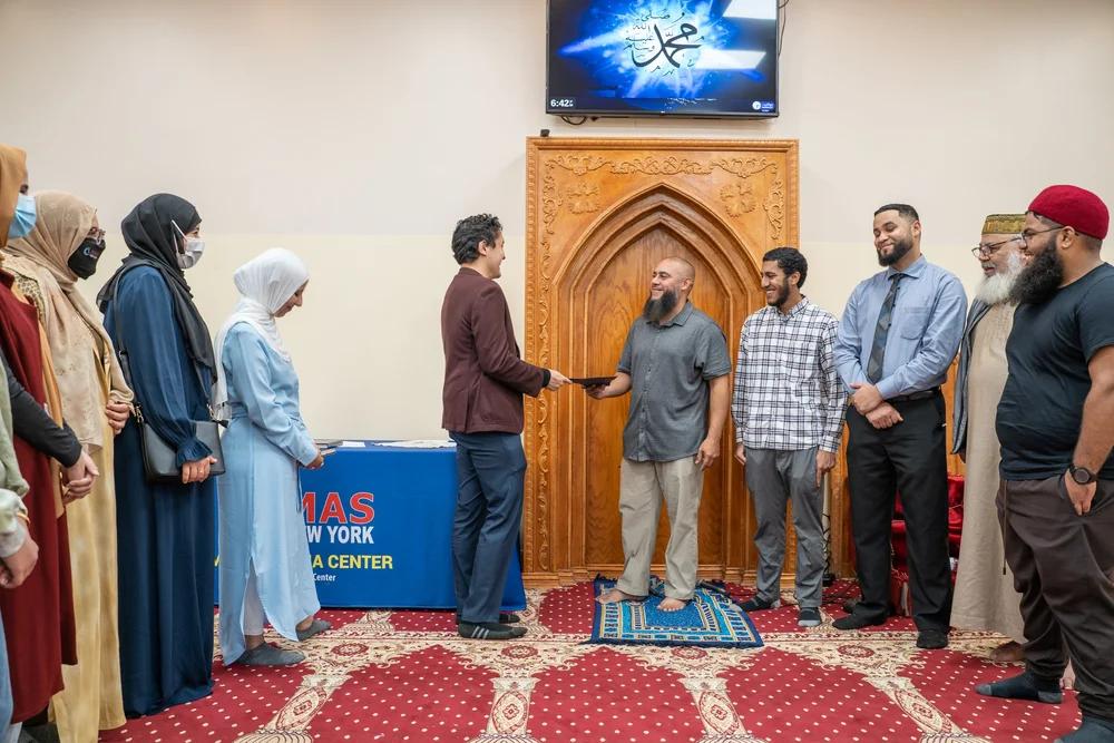 A new Muslim receiving their welcome at a shahada ceremony