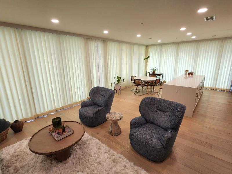 Floor-to-ceiling sheer white drapery panels lining living and dining room walls