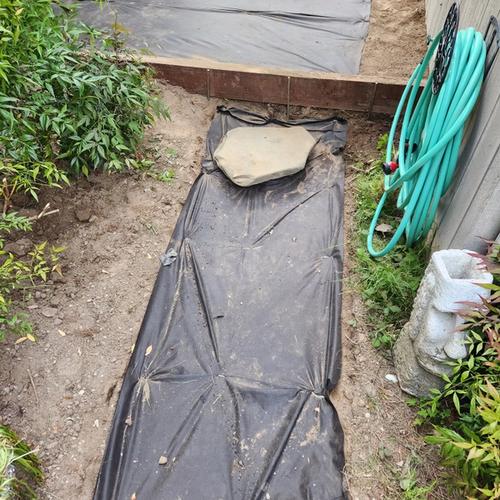 Creatively placed landscaping stone to provide access to the home's water shutoff