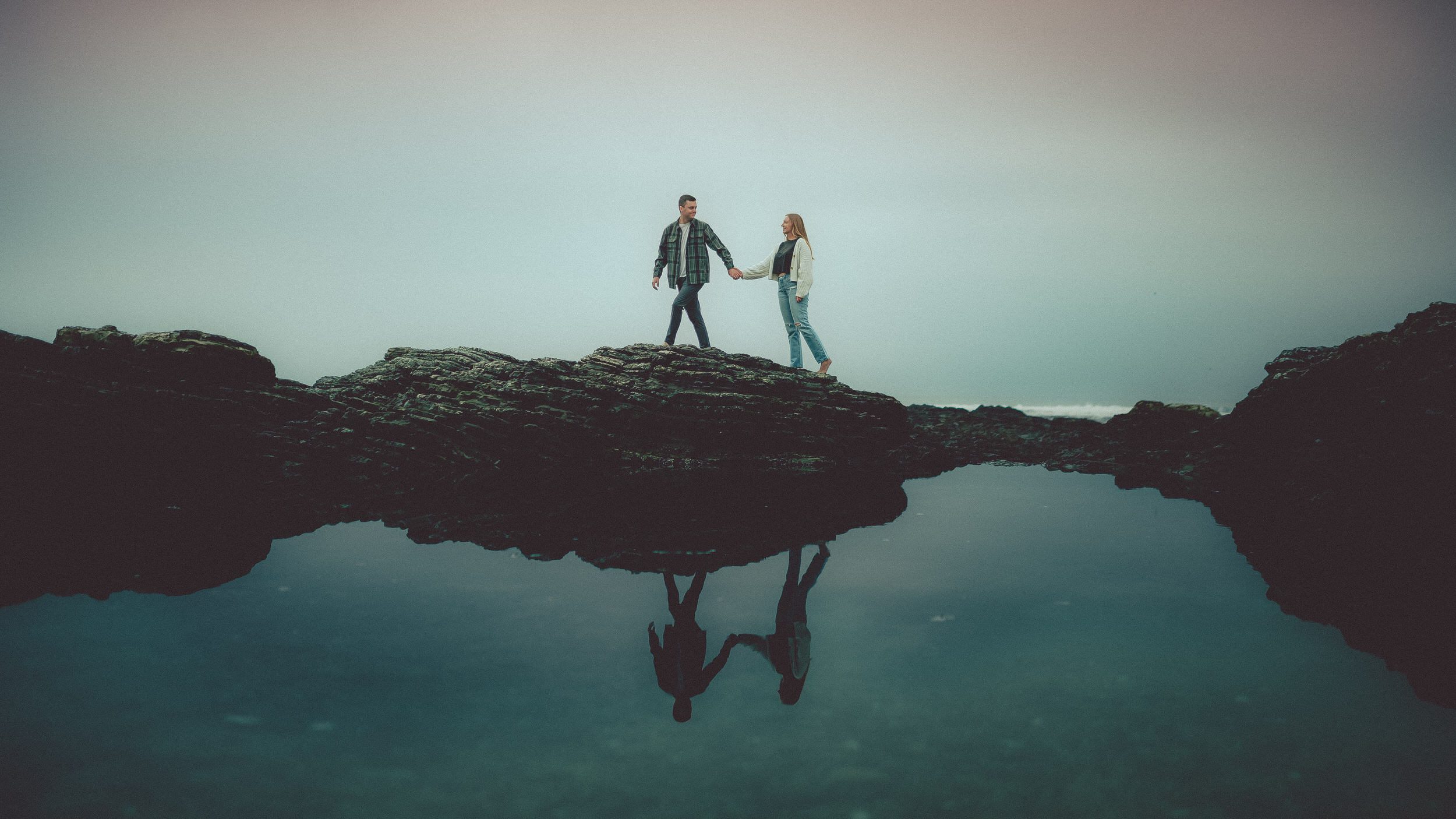 A couple reflected in a tidal pool on the Central Coast