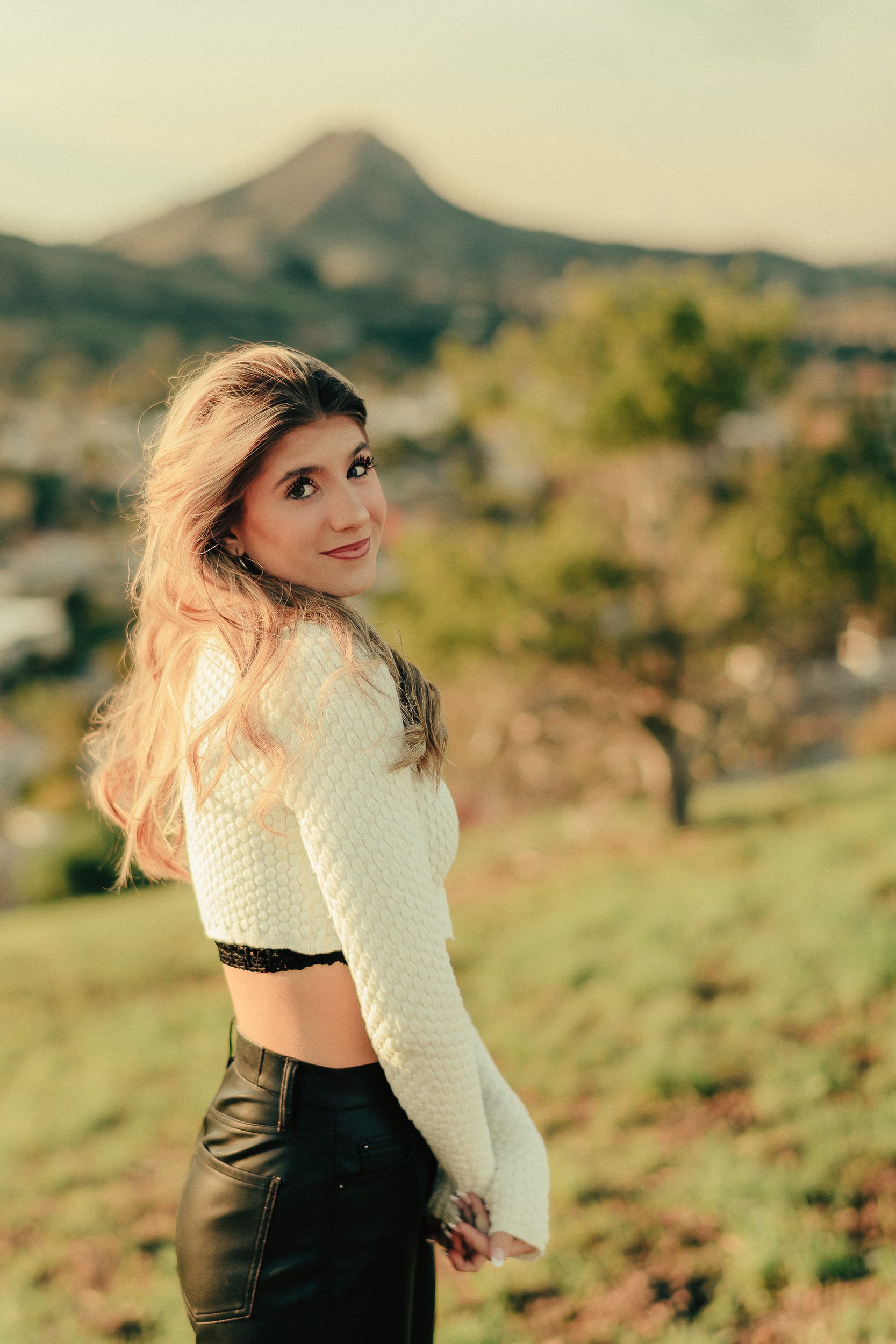 Senior portrait on coastal rocks with mountains in the distance