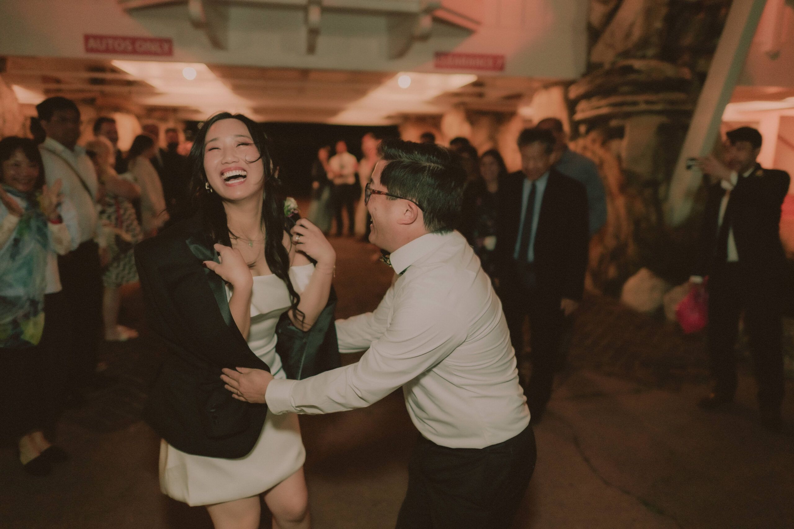 Alice and Ryan laugh together on the reception dance floor