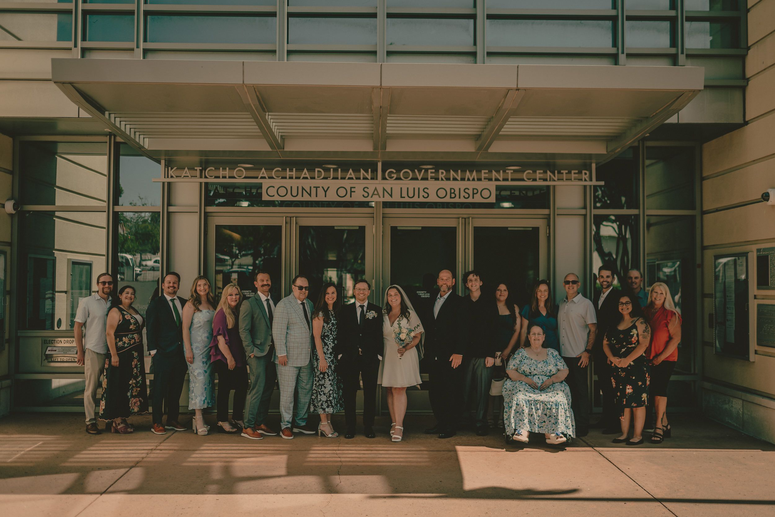Tiffani and Braden stand with their full wedding group outside the courthouse.