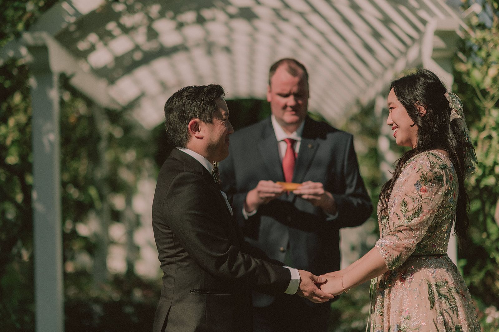 Wedding ceremony beneath a floral garden arch at the Madonna Inn