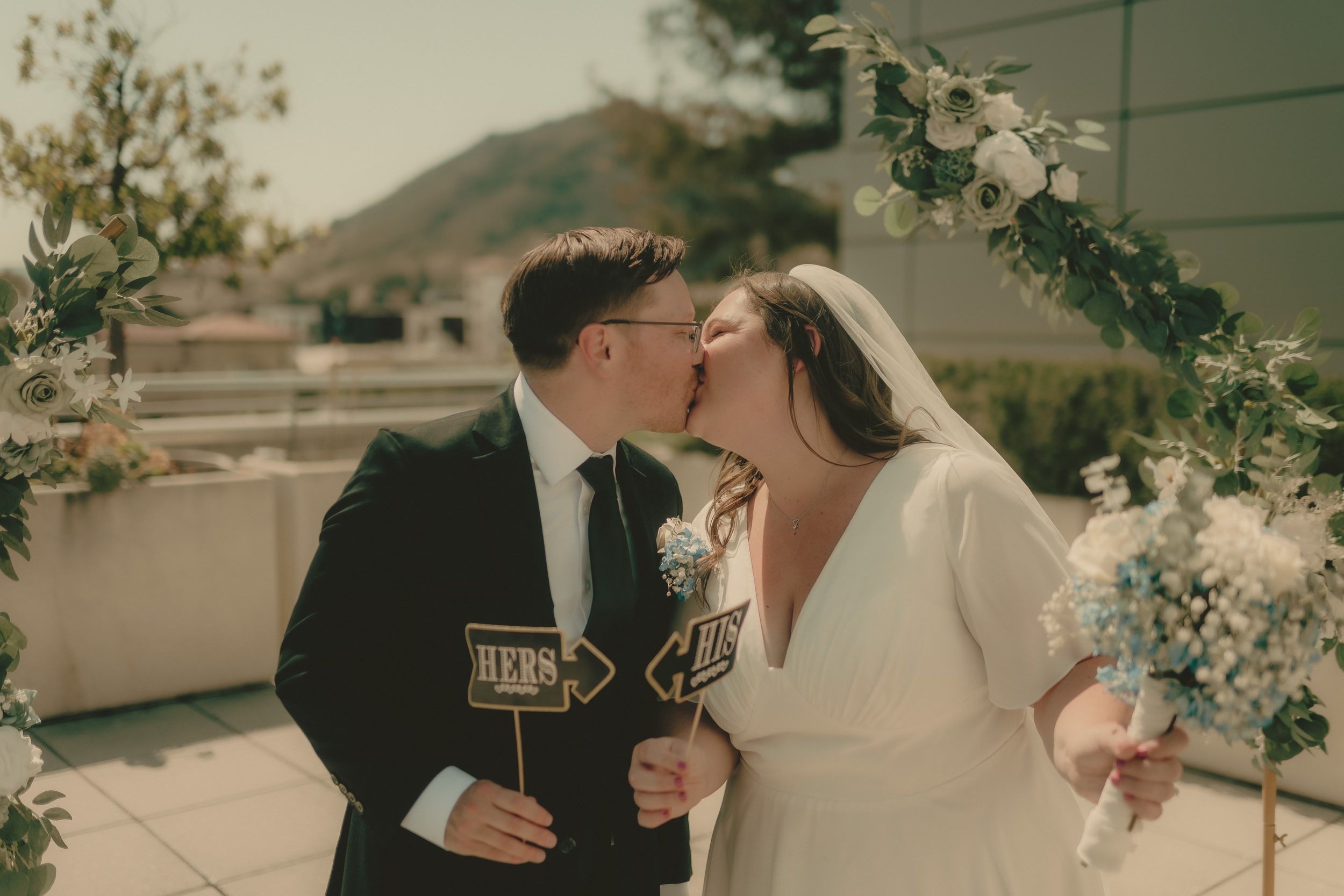 Tiffani and Braden share their first married kiss beneath the floral arch.