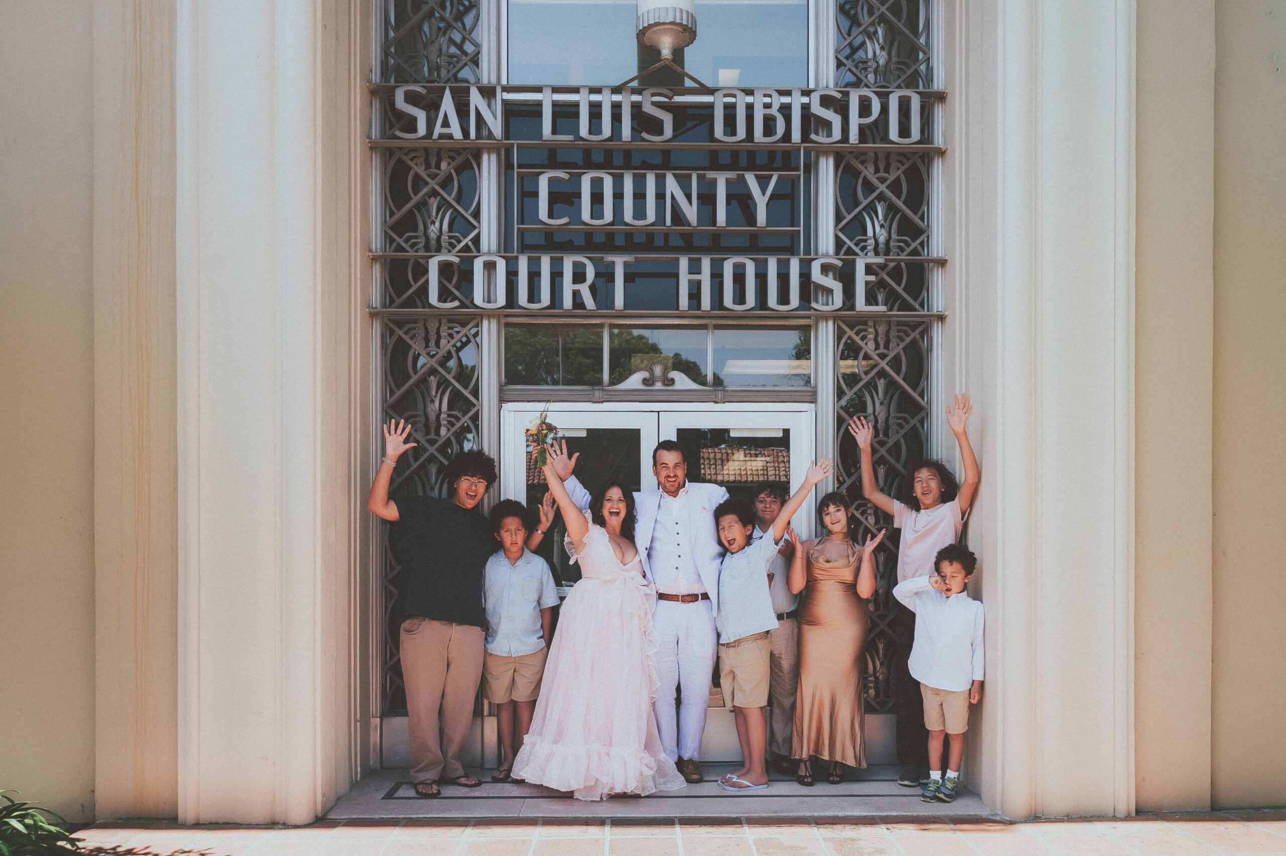 A wedding group cheering outside the San Luis Obispo County Courthouse.