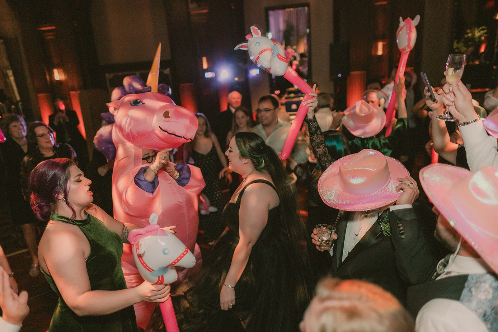 Anne dances among guests, pink cowboy hats and inflatable pony props.