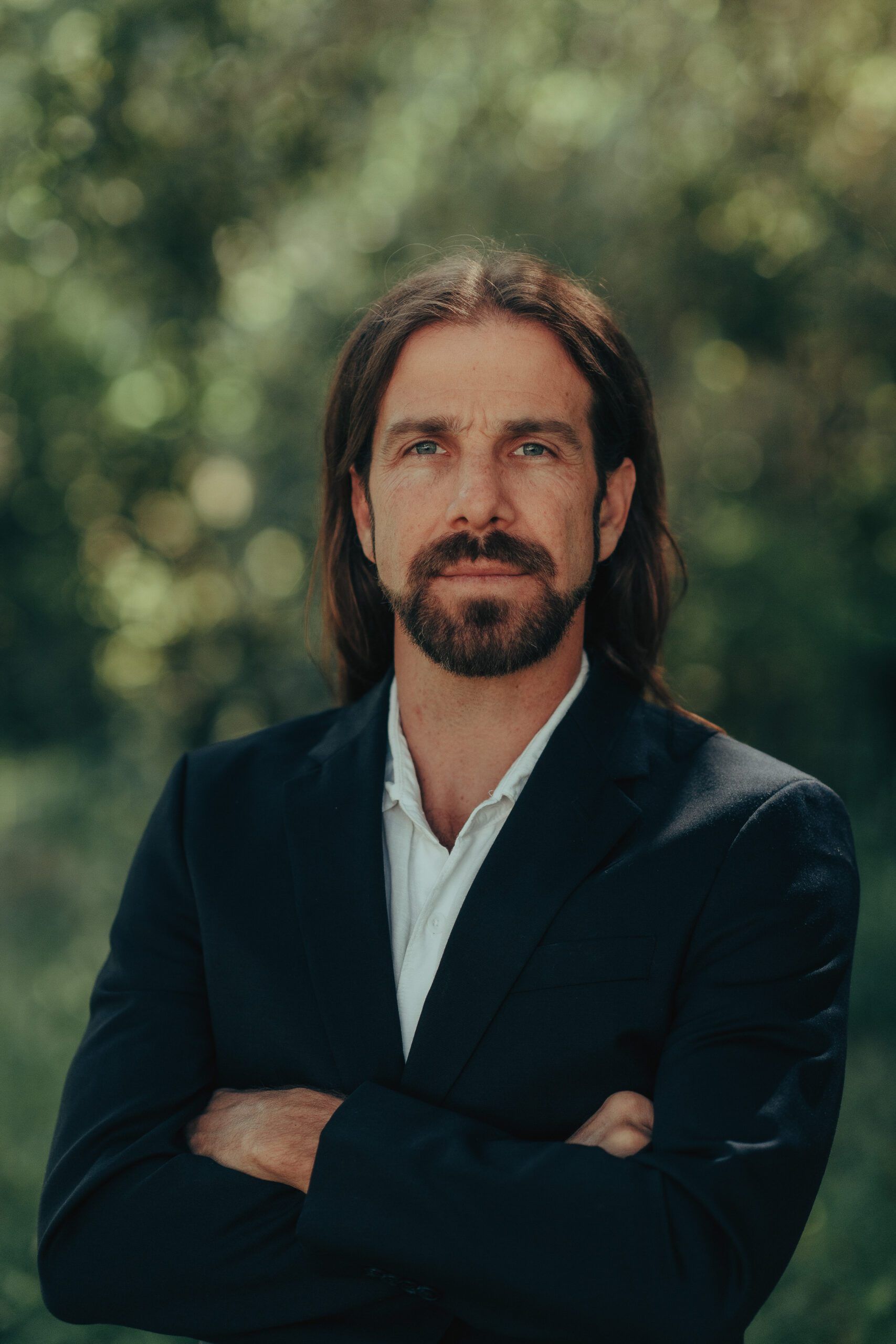 Outdoor professional portrait with softly lit green foliage