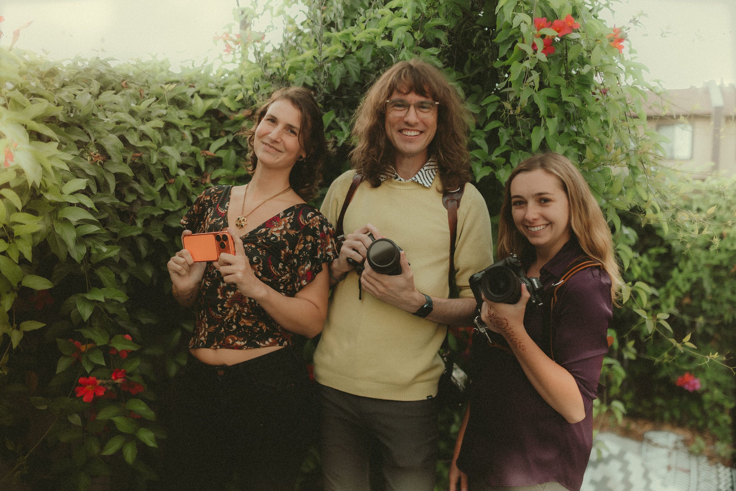 Faith, James Lester, and Makayla Grogan holding an iPhone and cameras together.