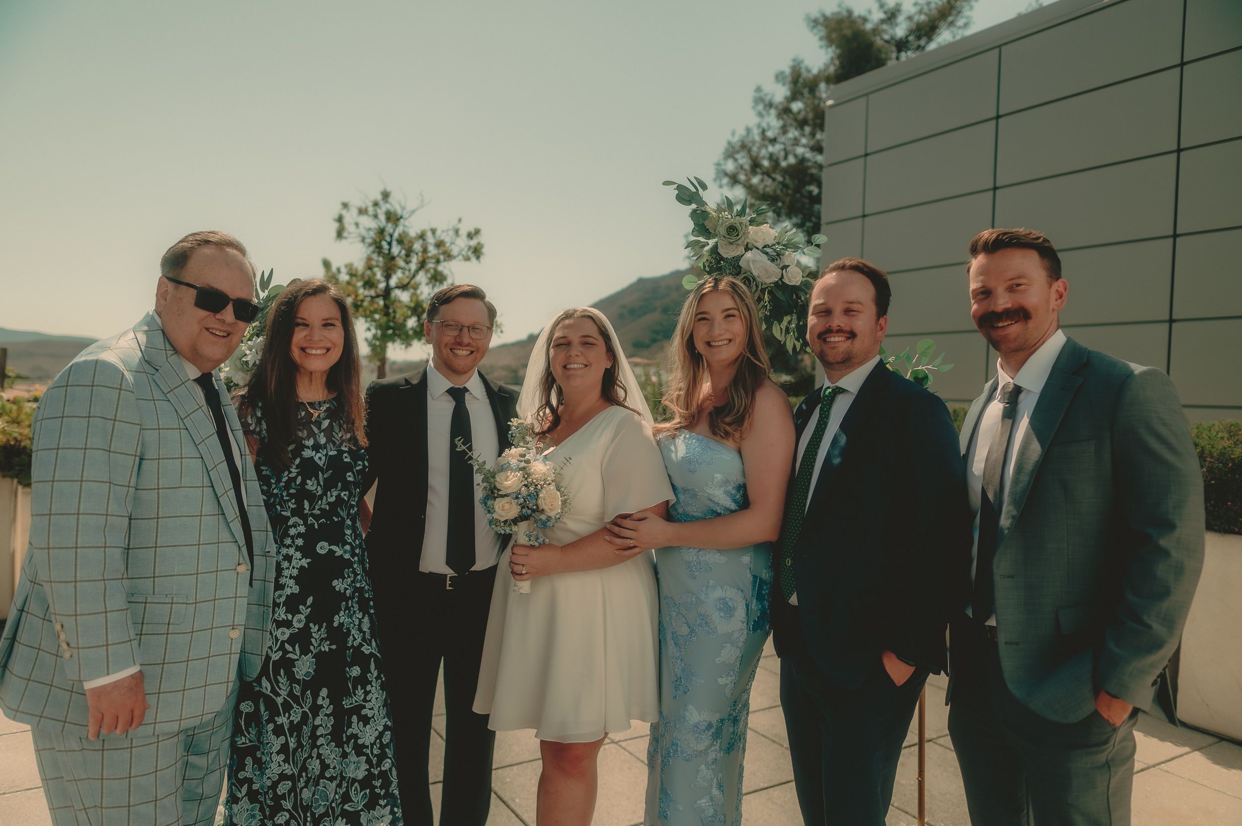 Tiffani and Braden stand with a group of wedding guests on the courthouse rooftop.