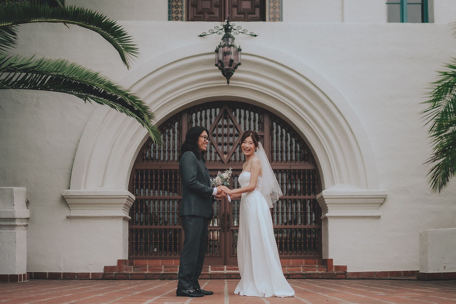Newlyweds beneath an arched Santa Barbara Courthouse entrance