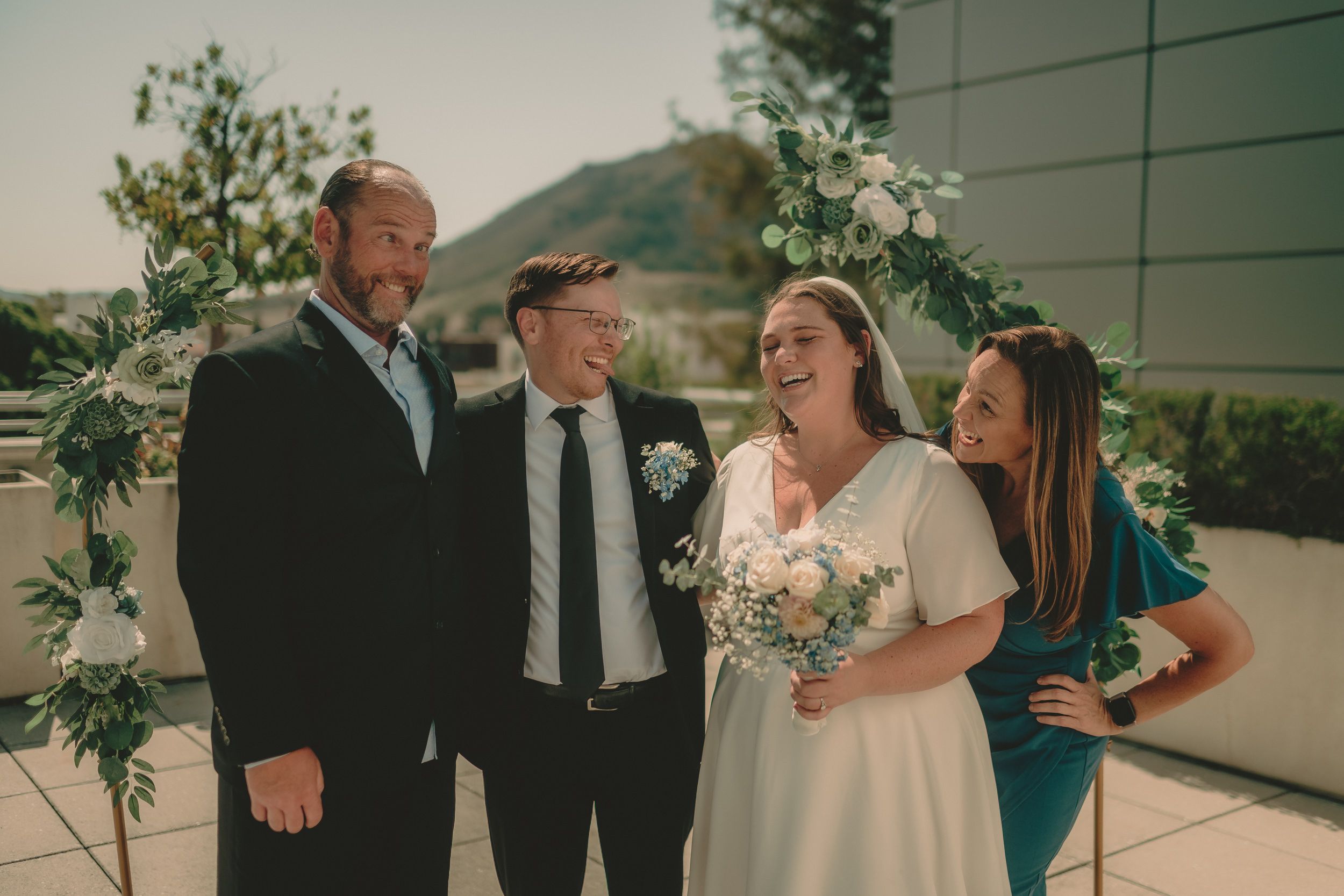 Tiffani, Braden and guests laugh together during family portraits.