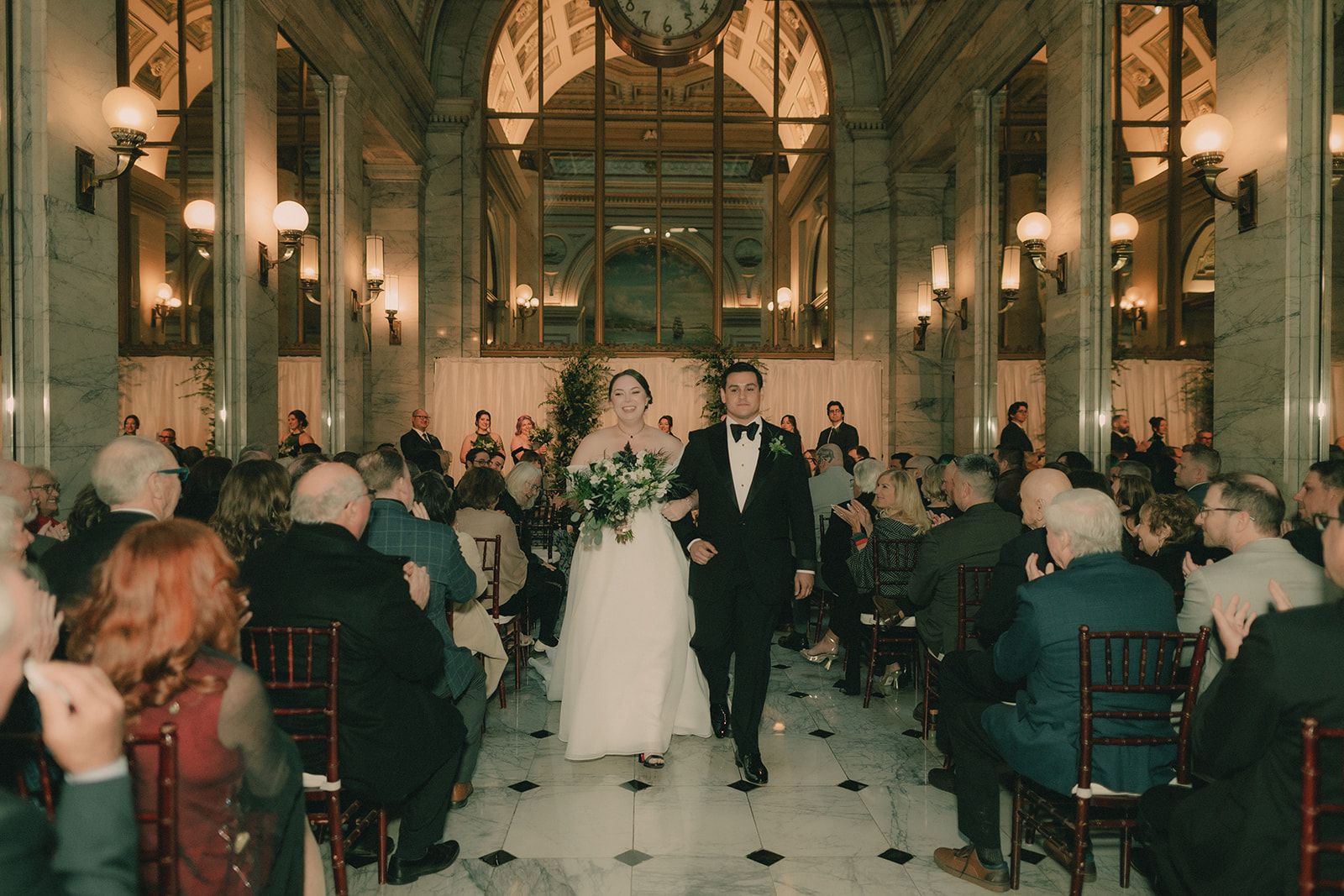 Anne and Charles walk back up the marble aisle together as their guests applaud.