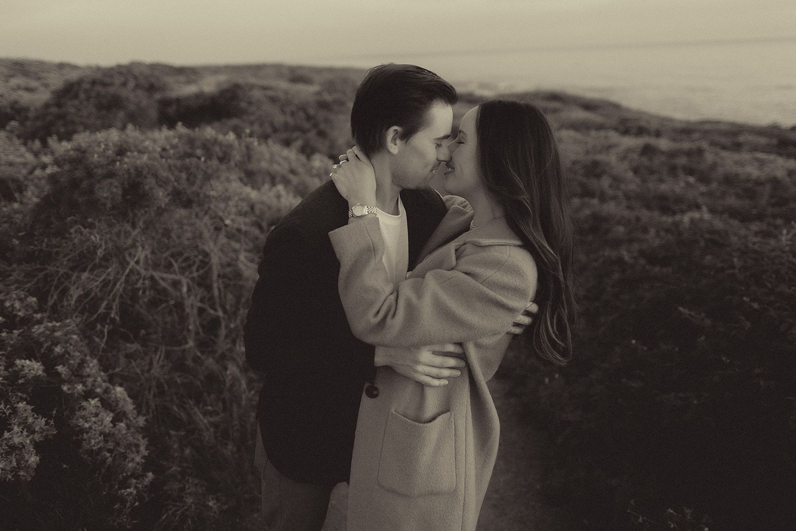 Black-and-white emotional embrace after a surprise proposal