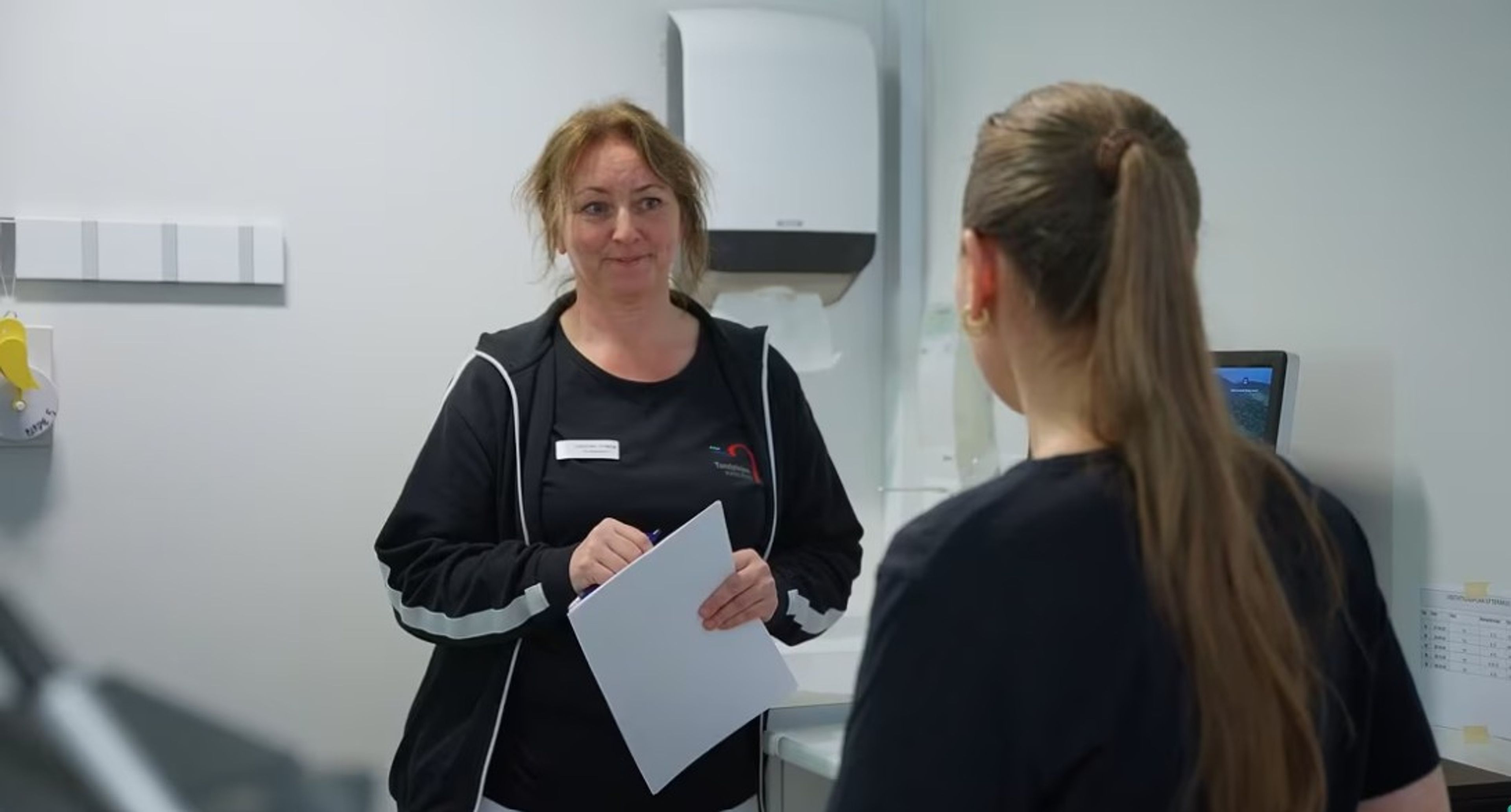 To klinikassistenter snakker sammen i klinikken