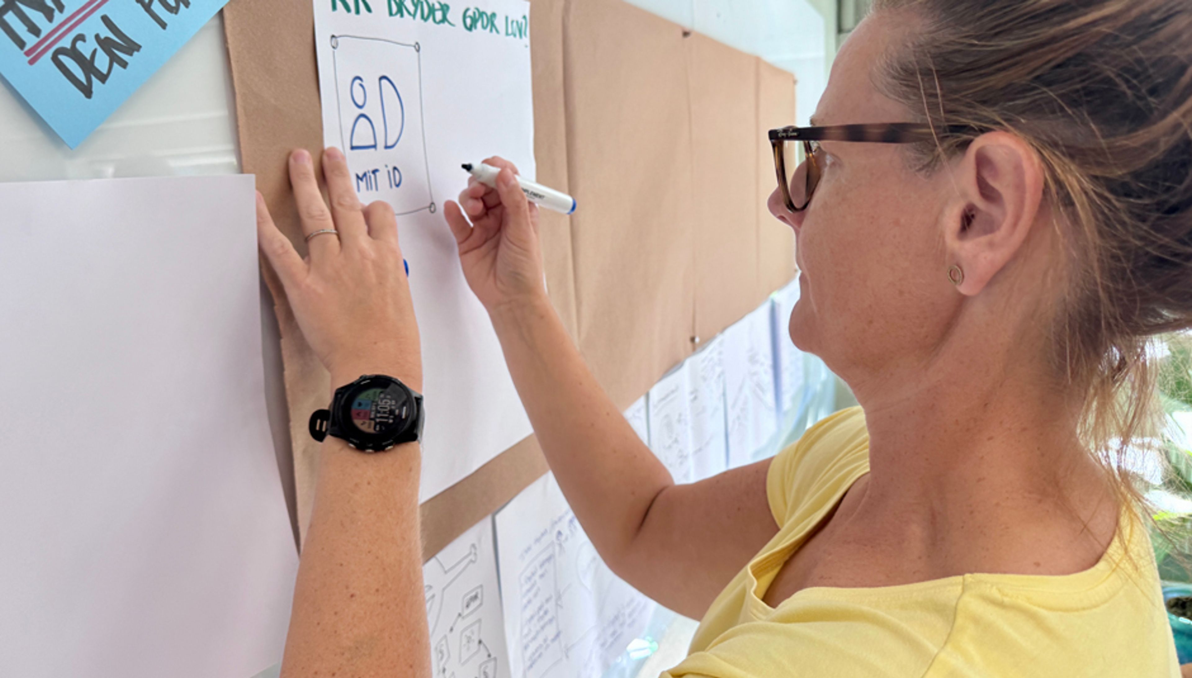 Sisse fra plejcenter skriver på planche