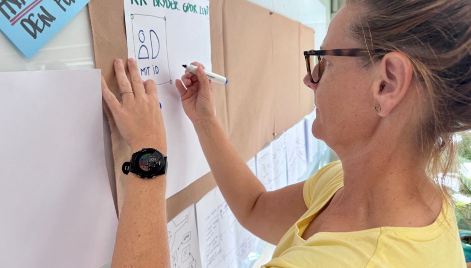 Sisse fra plejcenter skriver på planche