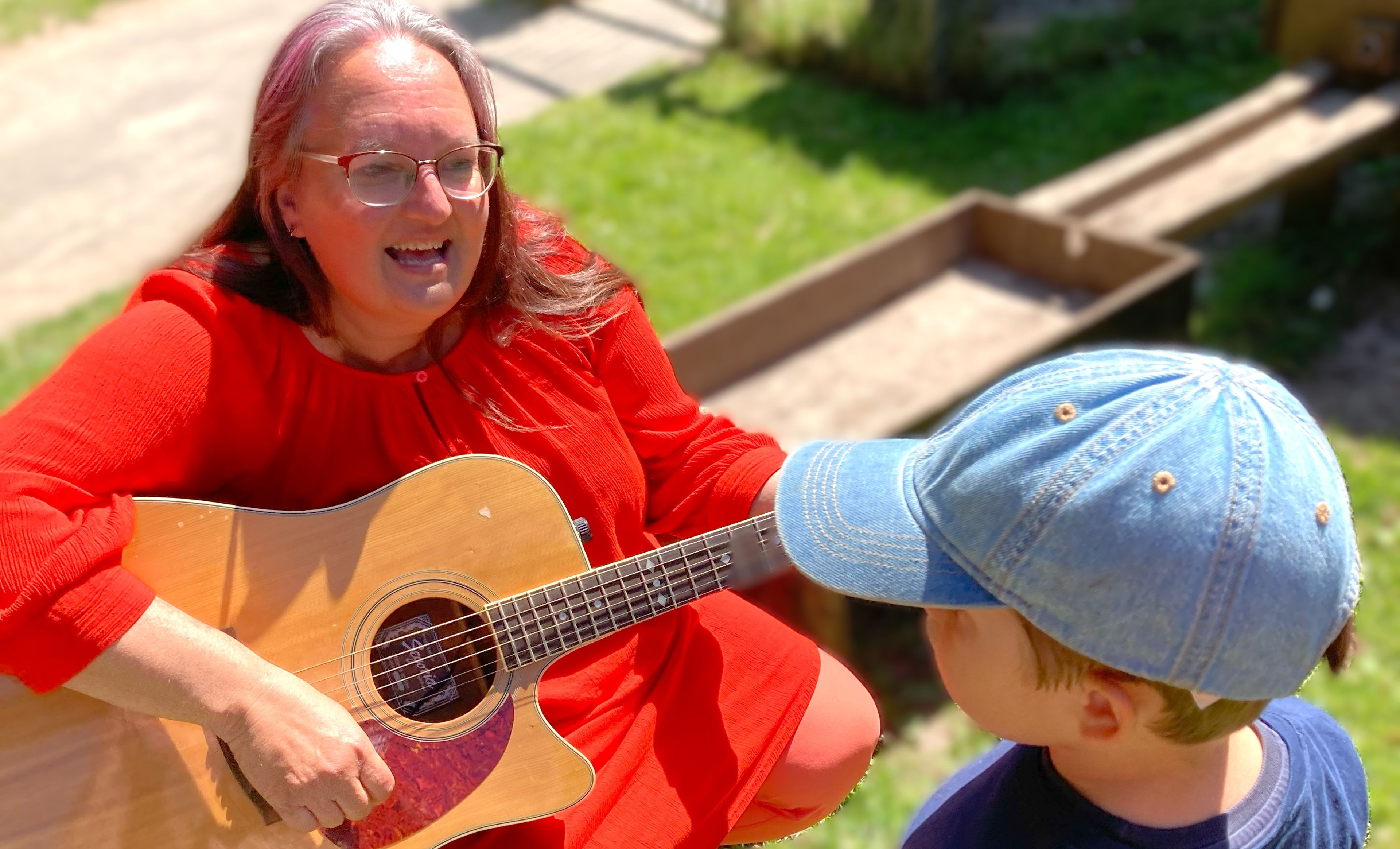 Pædagog spiller guitar for lille dreng