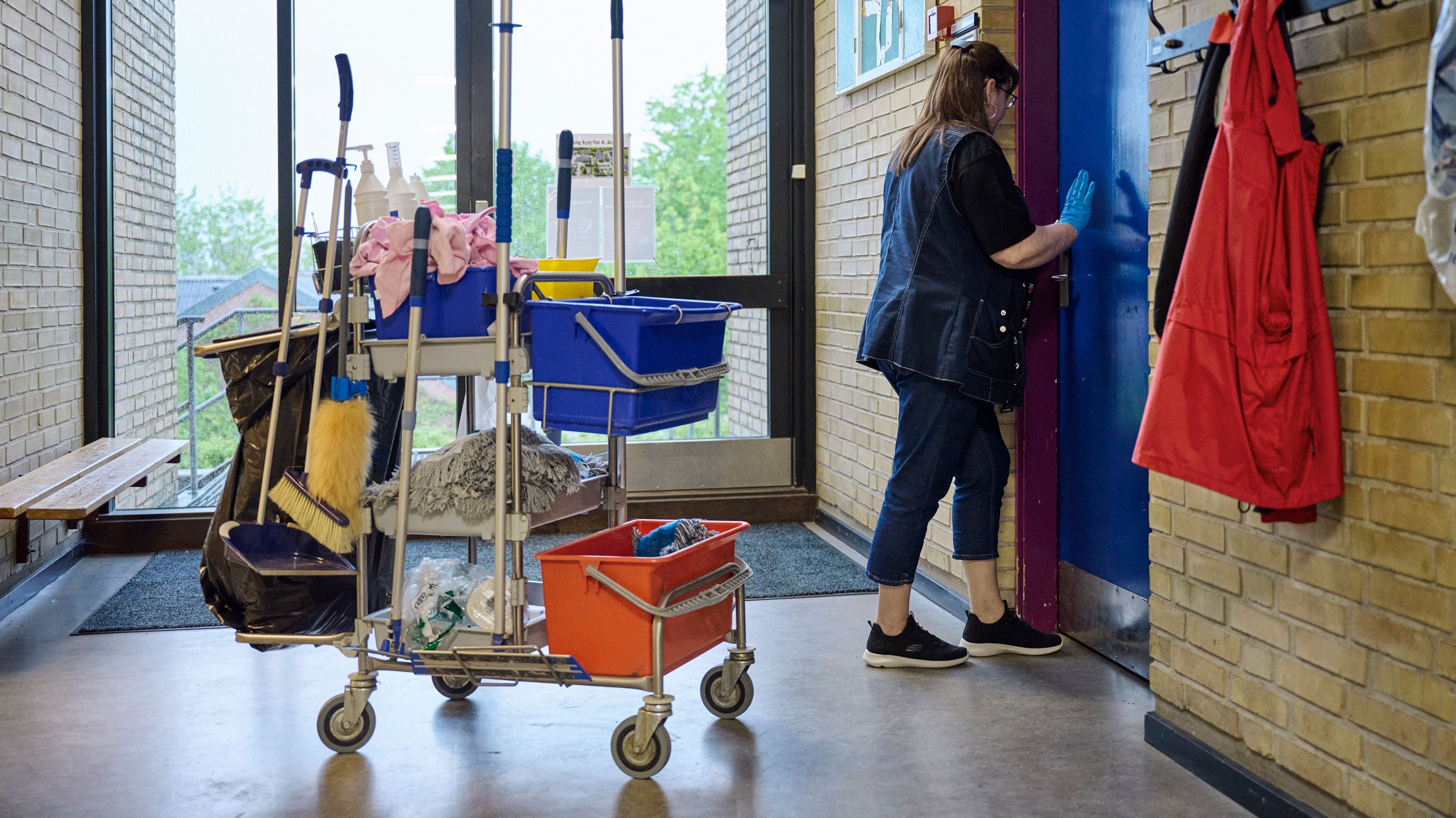 Rengøringsassistent med rengøringsvogn på en skole