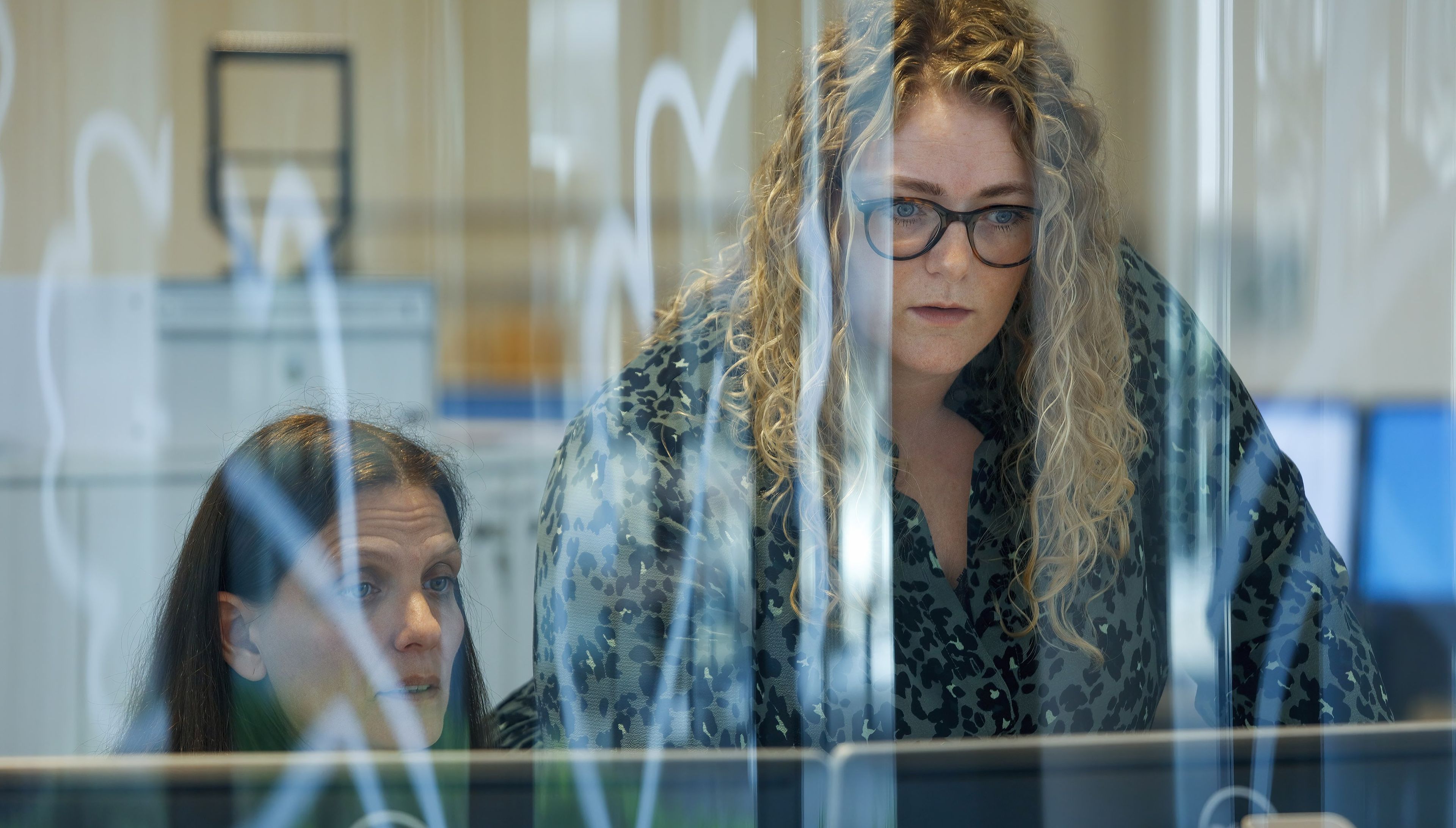 To HK-ansatte ser på to pc-skærme