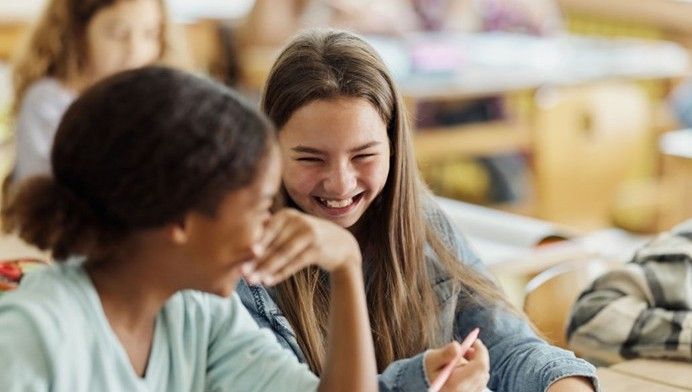 To piger på mellemtrinnet smiler til hinanden