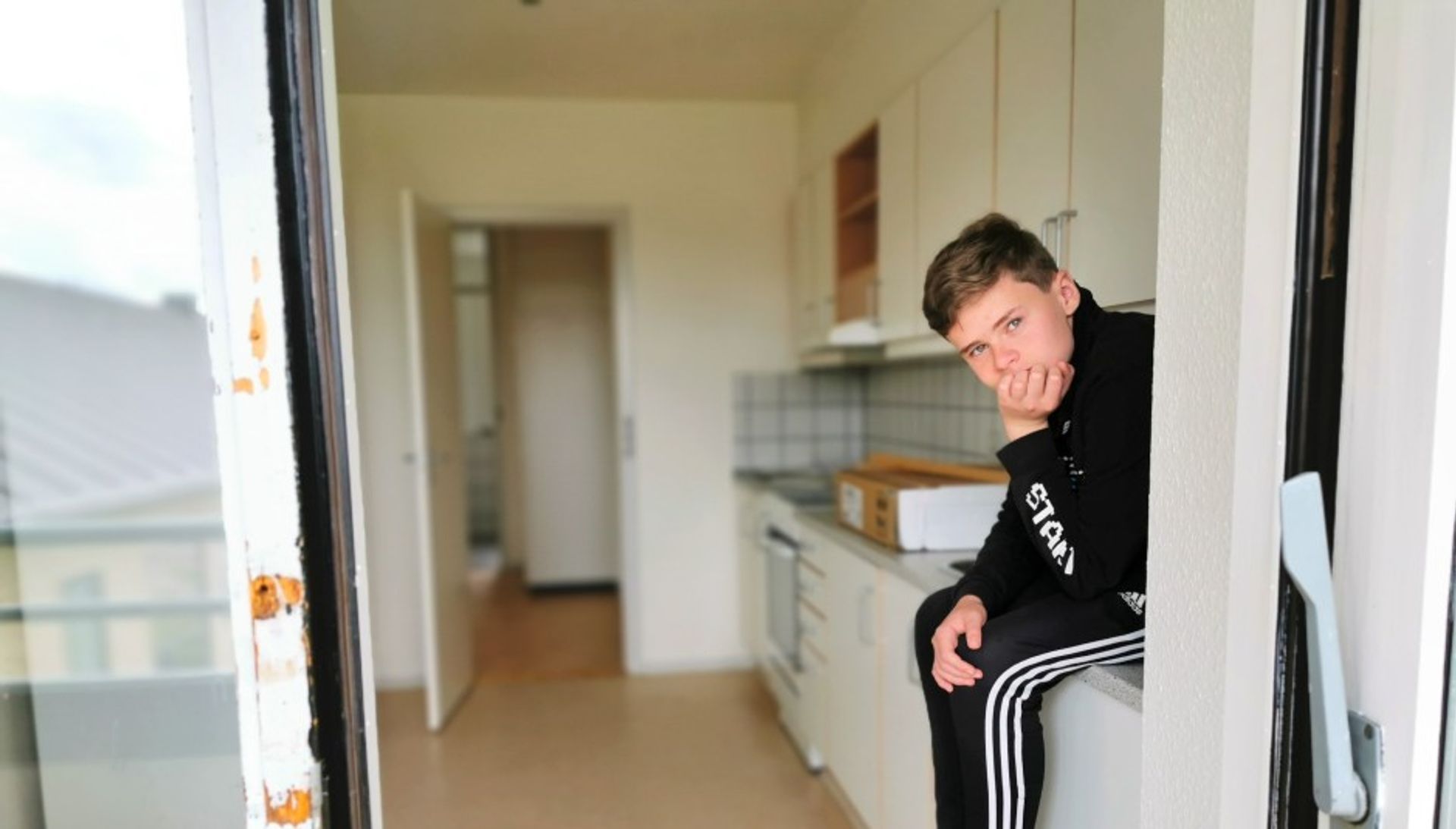 Dreng sidder på køkkenbord