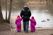 Kvindelig pædagog holder to børn i hånden