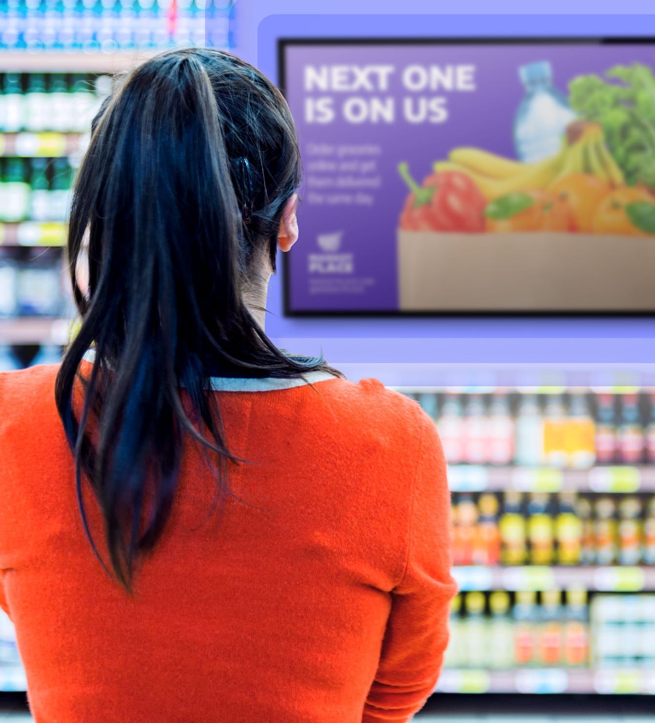 Customer viewing audio and video in-store Rockbot retail media screen in retail aisle